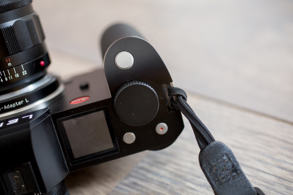 Keep it simple: nothing wrong with classic loops for attaching a camera strap.